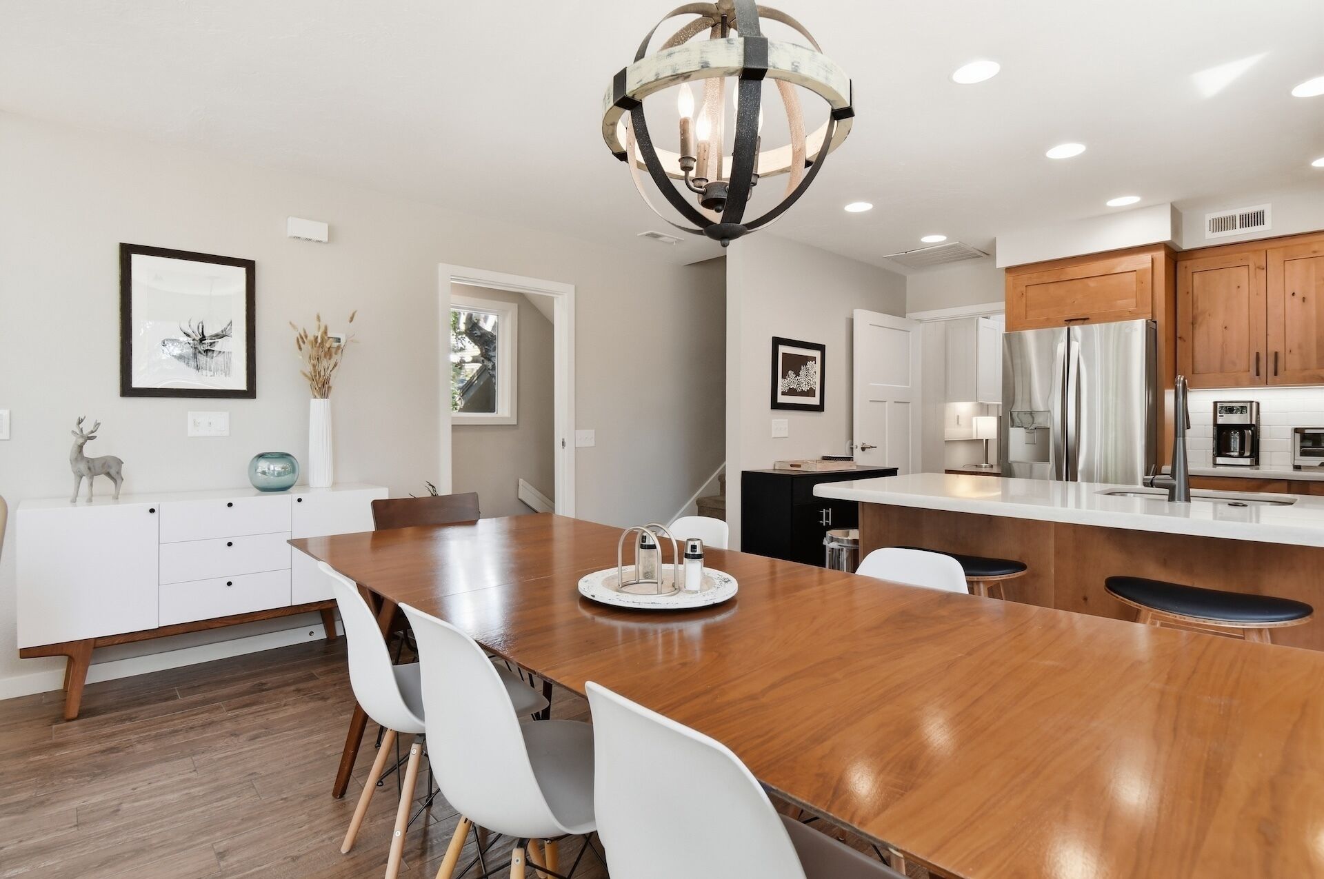 A modern kitchen with a wooden island, white cabinetry, and stainless steel appliances.