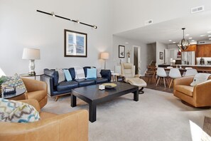 A modern living room with a sofa set, a coffee table, and a dining area with chairs. - Near Canyons Ski Lift w/ Communal Hot Tub (Park City)