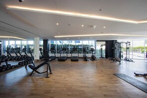 A spacious gym with treadmills, dumbbells, and weight machines. - Modern Studio with Private Pool and Balcony (Dubai)