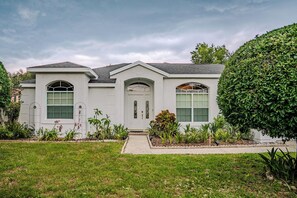 Uma casa térrea com entrada frontal, um pequeno alpendre e um jardim bem cuidado.