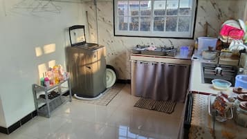 Una cocina con estufa, lavamanos y ventana.