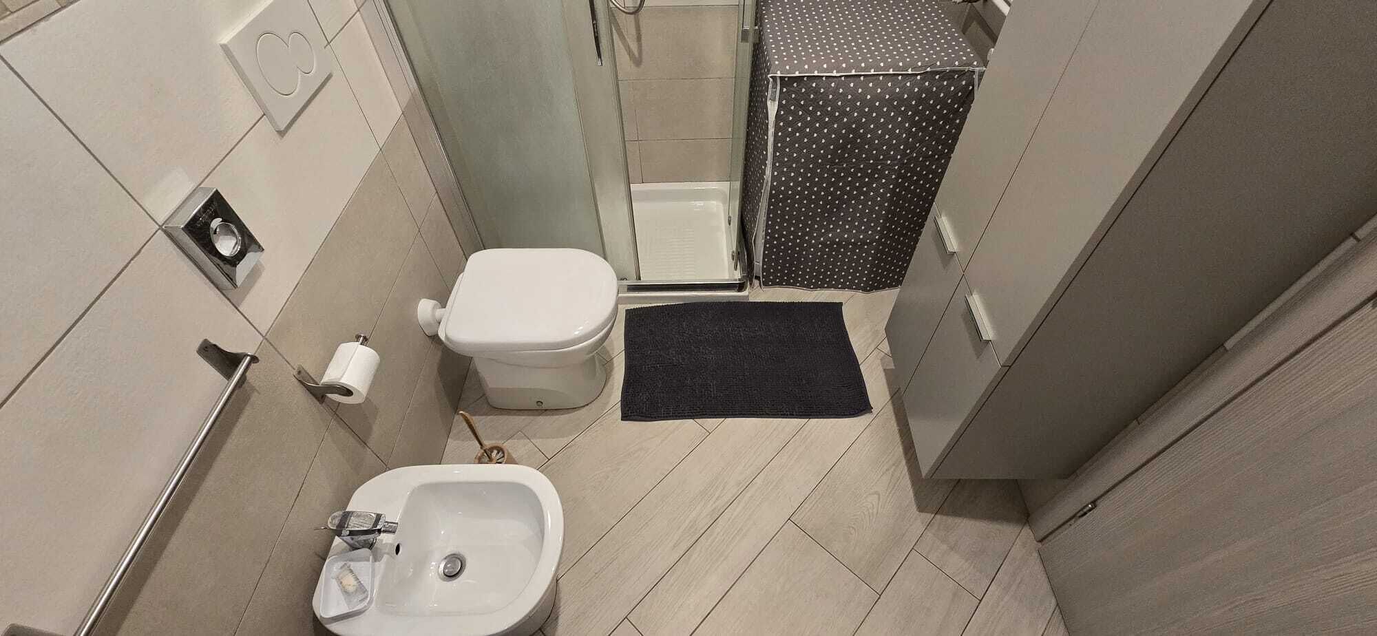 A small bathroom with a toilet, bidet, and sink.