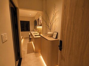 A modern kitchen with a wooden countertop, a sink, and a vase with branches. - Aurora Stay Inn Saigon (Ho Chi Minh City)