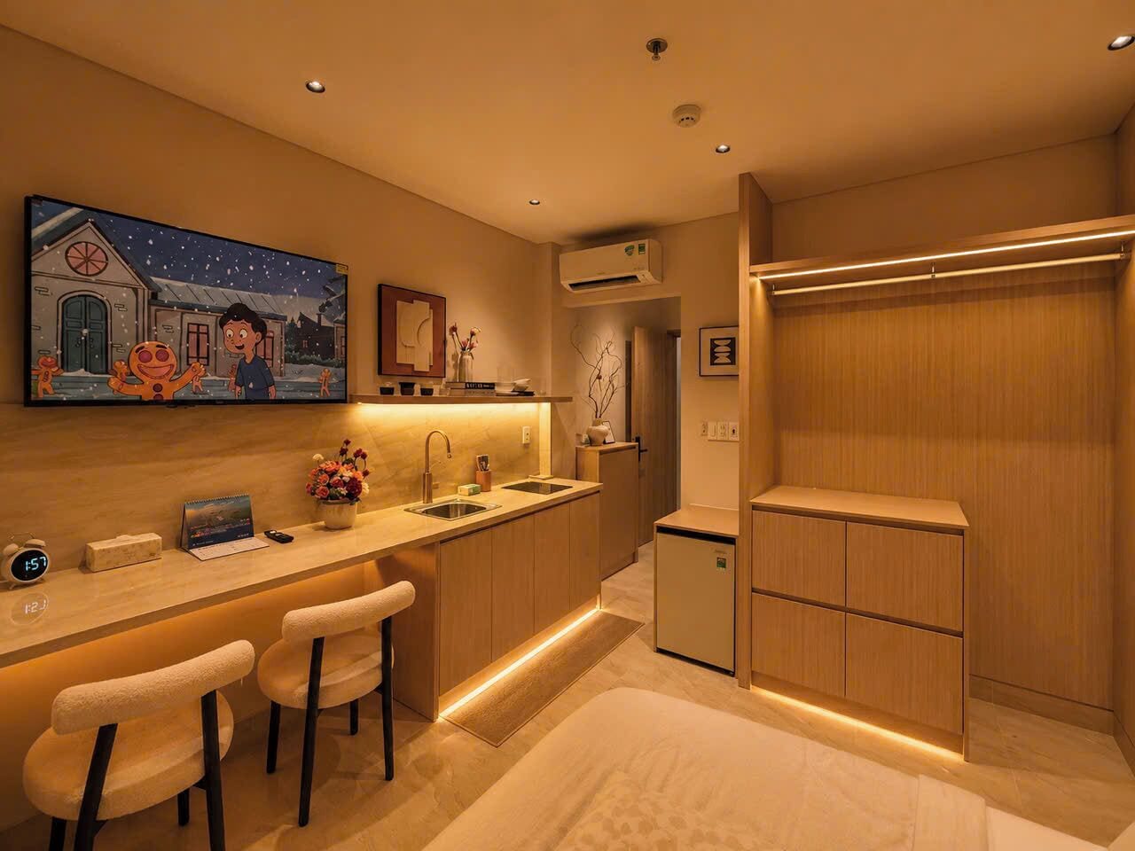 A modern kitchen with a bar area, a small refrigerator, and a painting on the wall.