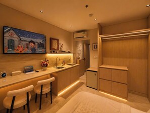 A modern kitchen with a bar area, a small refrigerator, and a painting on the wall. - Aurora Stay Inn Saigon (Ho Chi Minh City)