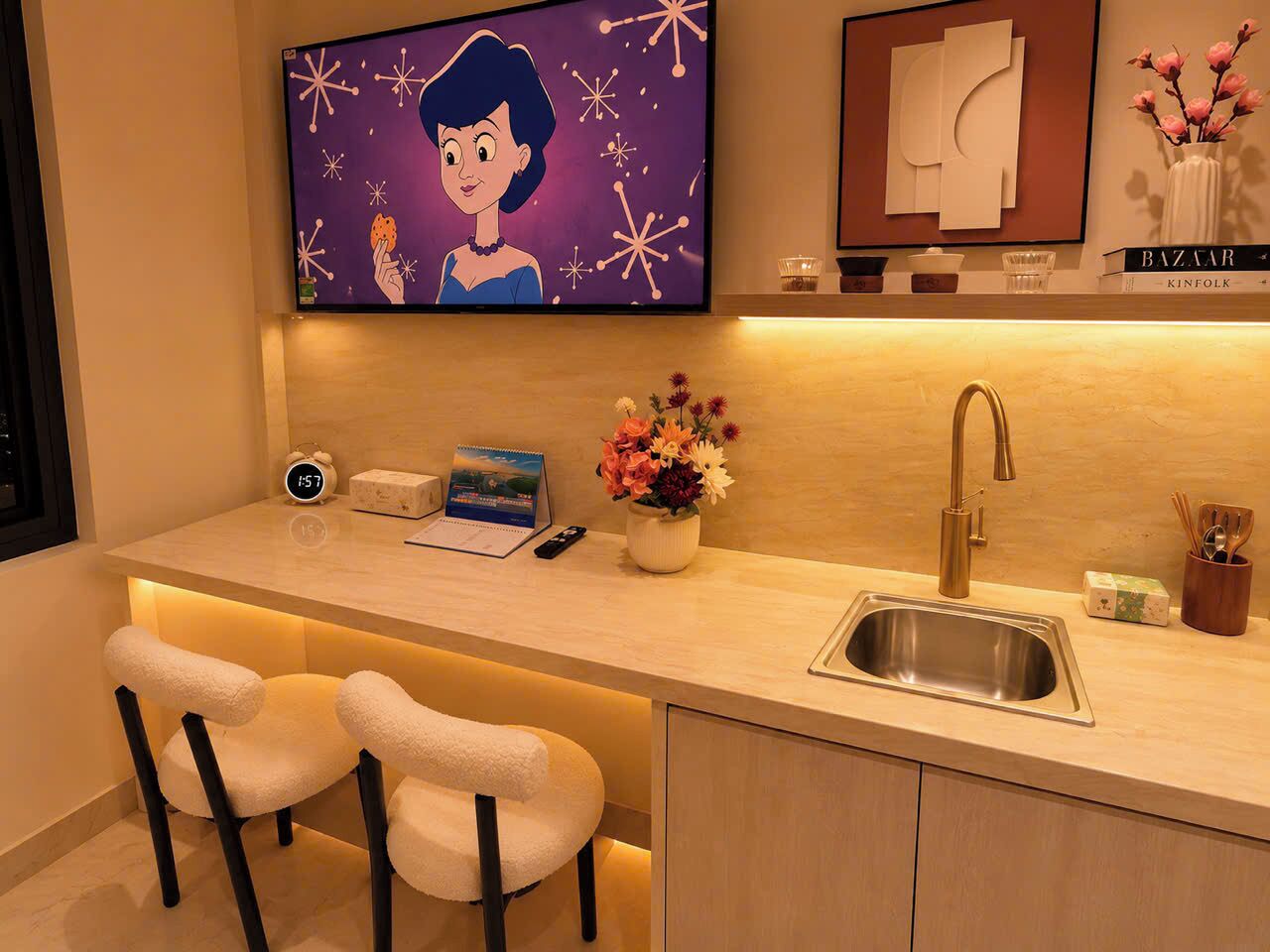 Una cocina moderna con pileta integrada, cafetera y un pequeño espacio de estar con dos sillas.