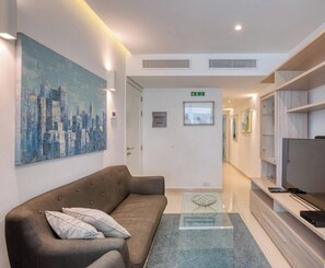 Eine moderne Hotelhalle mit einer Couch, Kunstwerken, einem Fernseher und einer Rezeption.