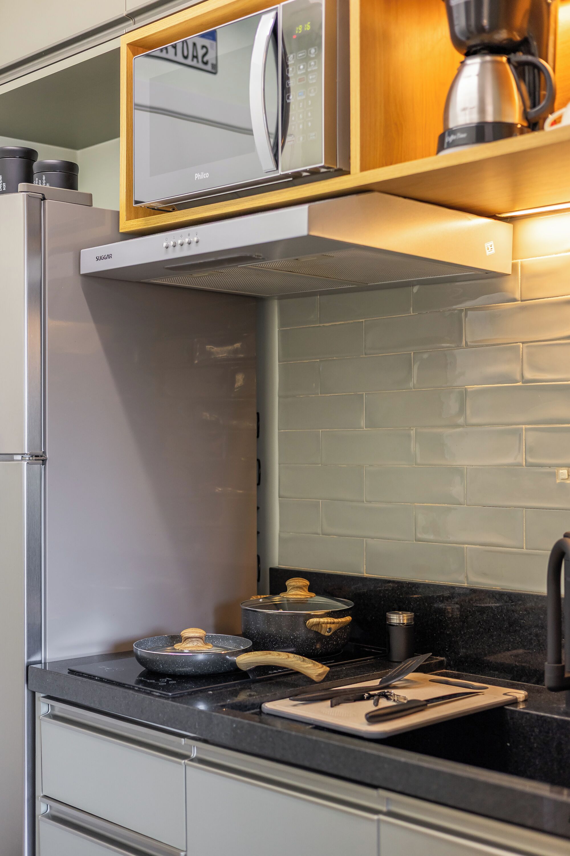 A kitchen with a built-in oven, a coffee maker, and a stove.