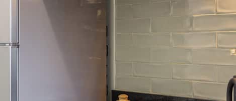 Una cocina con horno empotrado, cafetera y estufa.