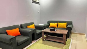 A living room with two sofas, a coffee table, and a patterned rug.