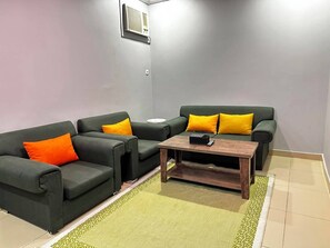 A living room with two sofas, a coffee table, and a patterned rug.