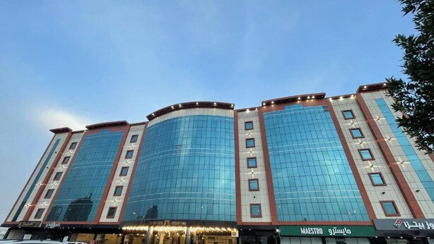 A multi-story hotel with a curved facade, large windows, and signage for 'MAESTRO' and 'MAESTRO 9'.