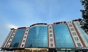 A multi-story hotel with a curved facade, large windows, and signage for 'MAESTRO' and 'MAESTRO 9'. - Bawabat Al Worood Serviced Apartments (taif)