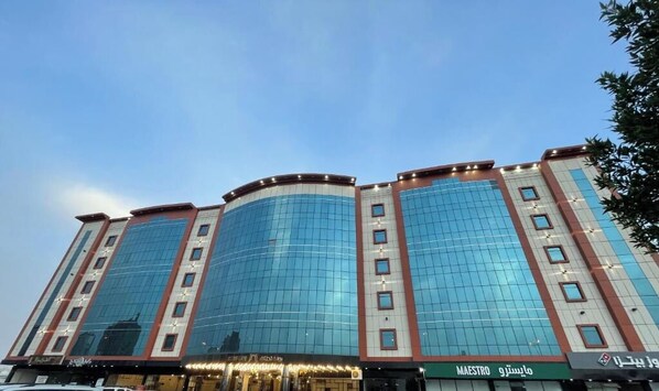 A multi-story hotel with a curved facade, large windows, and signage for 'MAESTRO' and 'MAESTRO 9'.