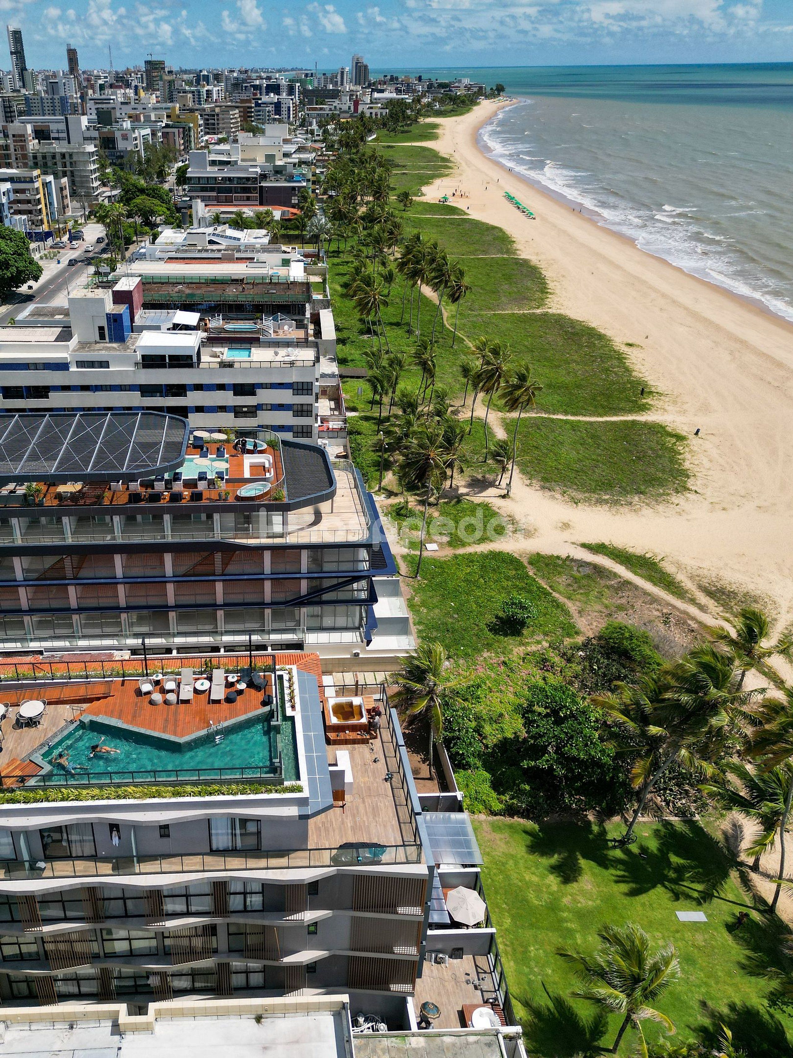 A modern hotel with a rooftop pool and a beach view.