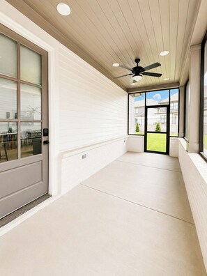 A corridor with a ceiling fan, large windows, and a view of a building outside. - The Grove Haven, 2mi-SQ+Pool by Velvet Ditch Villas (Oxford)