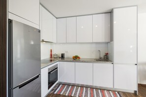 Une cuisine moderne avec des armoires blanches, des appareils en acier inoxydable et un comptoir en granit.