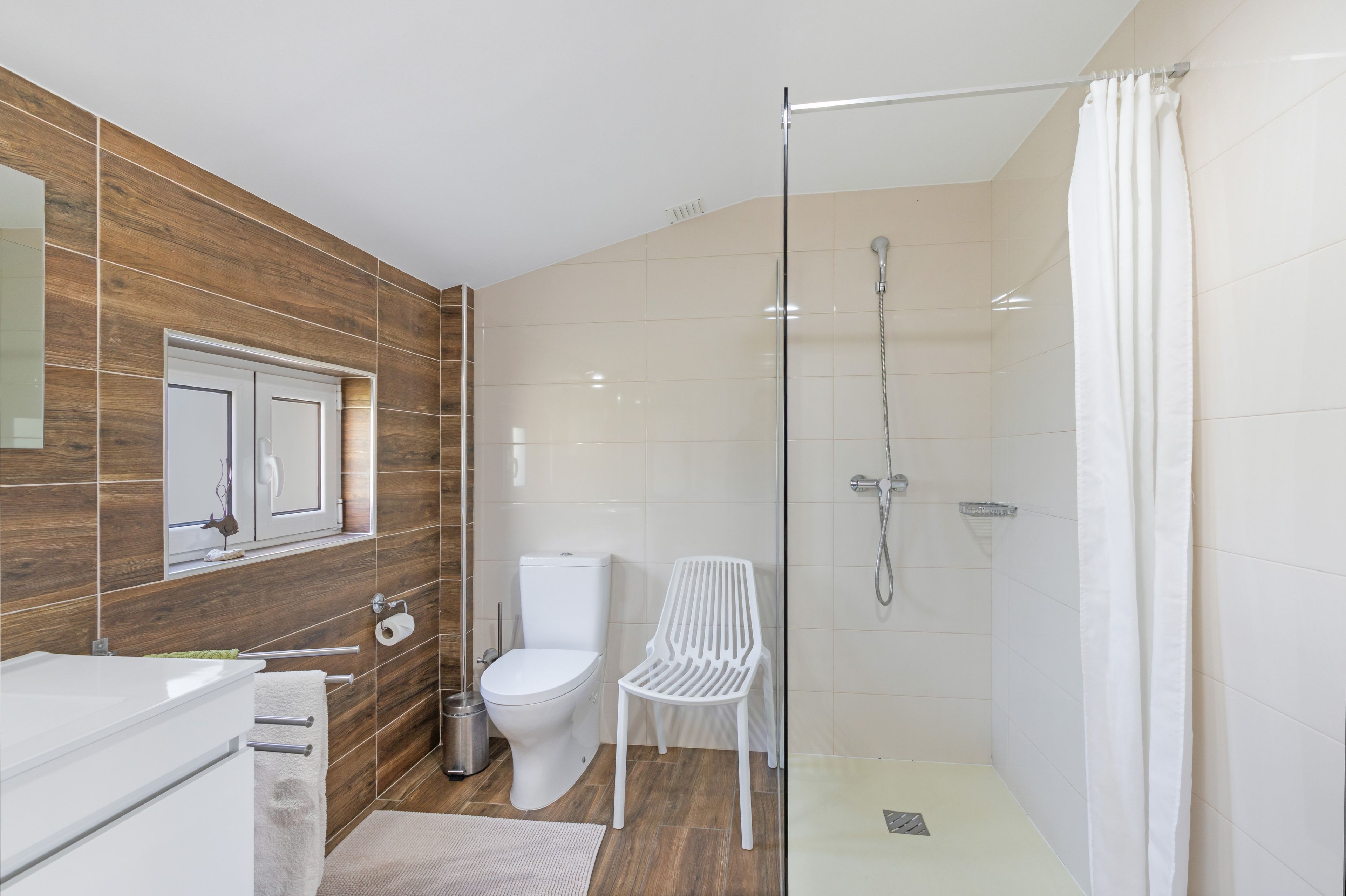 Un baño moderno con ducha envuelta en vidrio, inodoro y lavamanos.