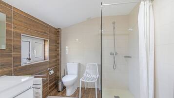 Un baño moderno con ducha envuelta en vidrio, inodoro y lavamanos.