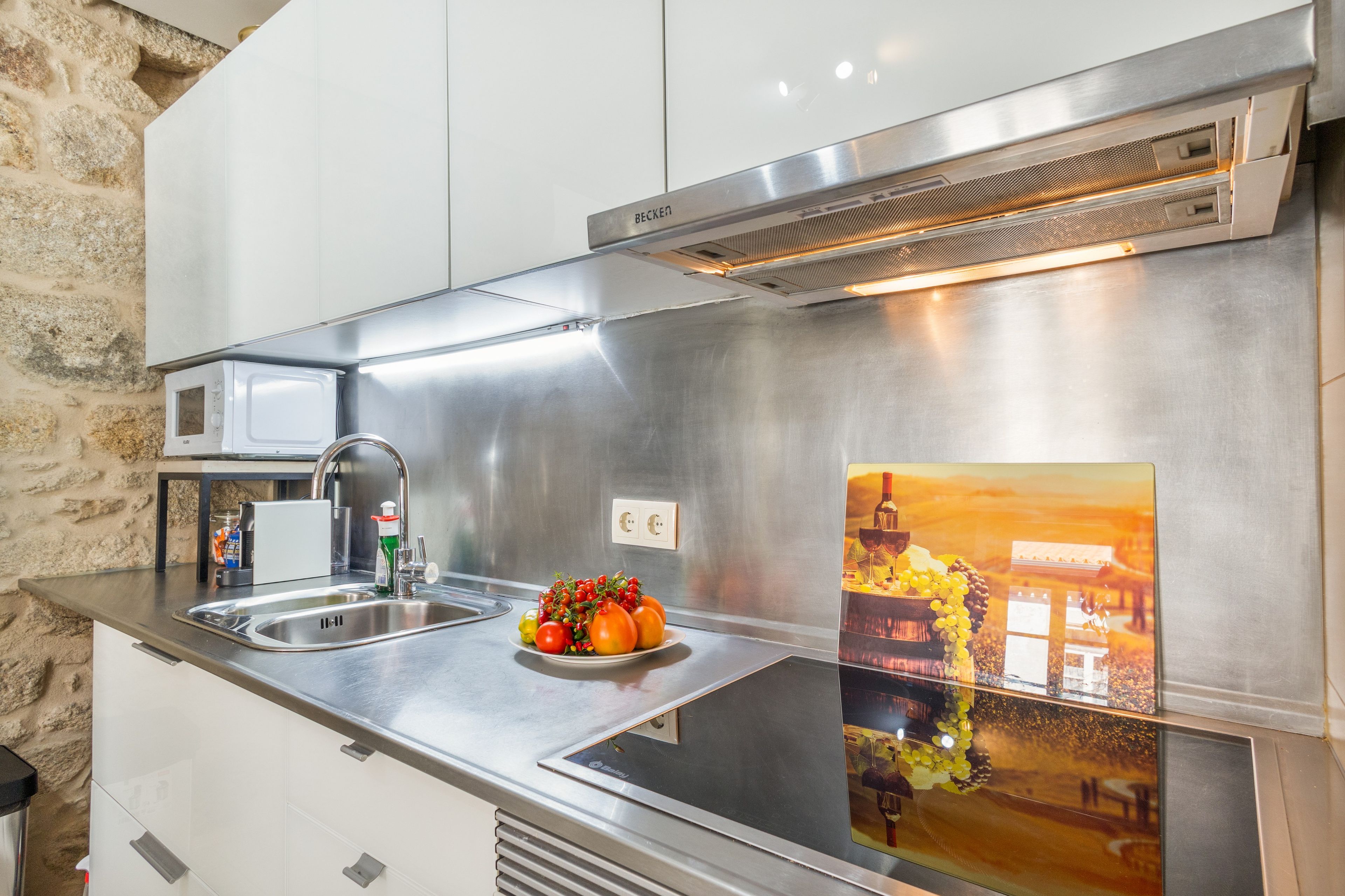 Une cuisine moderne dotée d’appareils électroménagers en acier inoxydable, d’un évier et d’un crédence décorative.