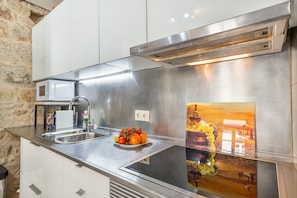 A modern kitchen with stainless steel appliances, a sink, and a decorative backsplash.
