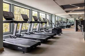 A gym with multiple treadmills, exercise bikes, and other fitness equipment.