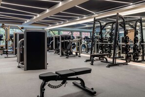 A modern gym with various exercise equipment, including weight machines and free weights. - King | Arlo DC | Judiciary Square | Capital One Arena (Washington)