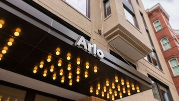 Ein Gebäude mit einem Schild, auf dem 'Arlo' steht, über einer Reihe von Lichtern.