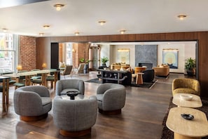 A spacious lobby with a mix of seating options, including sofas and chairs, and a fireplace.