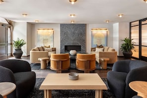 A modern lounge area with sofas, armchairs, and a coffee table.