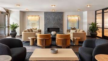 Eine moderne Lounge-Ecke mit Sofas, Sesseln und einem Couchtisch.
