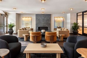A modern lounge area with sofas, armchairs, and a coffee table.