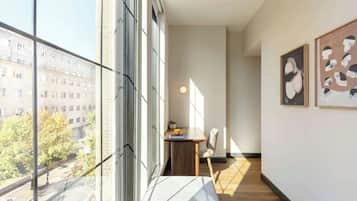 Ein modernes Interieur mit großen Fenstern, Holzboden und Kunstwerken an den Wänden.