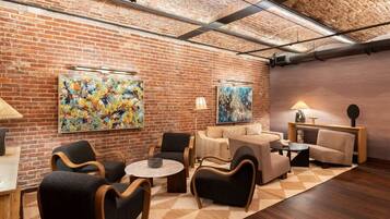 Eine moderne Lounge mit Backsteinwänden, abstrakter Kunst und zeitgemäßen Möbeln.