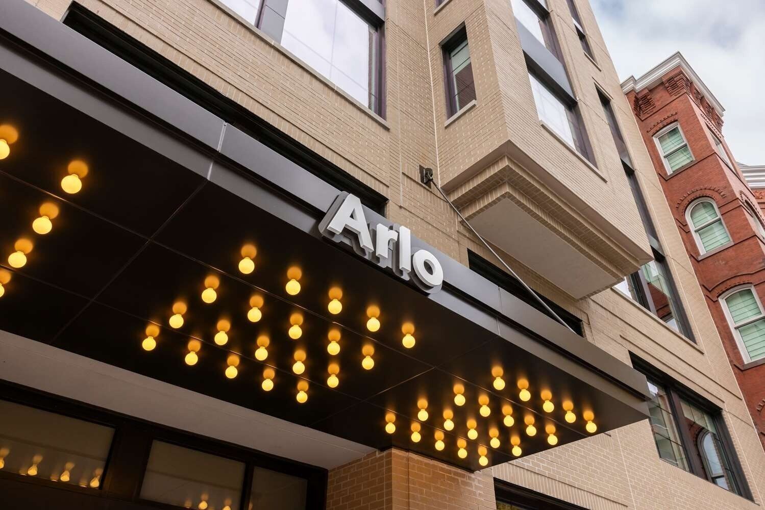 Ein Gebäude mit einem Schild, auf dem 'Arlo' steht, über einer Reihe von Lichtern.
