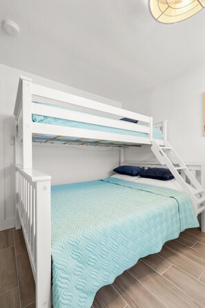A bunk bed with a ladder, a blue quilt, and a blue pillow. - Coastal Stay by Dunedin Causeway (Dunedin)