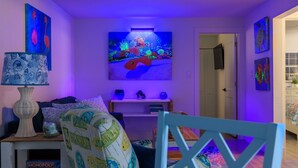 Un salon avec un téléviseur, un canap é, une table basse et un fauteuil.