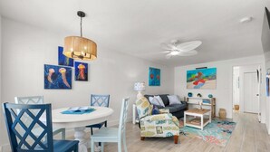 Un coin repas avec une table ronde, des chaises et un ventilateur de plafond.