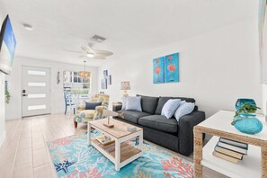 A modern living room with a grey sofa, a coffee table, and a patterned rug. - Coastal Stay by Dunedin Causeway (Dunedin)