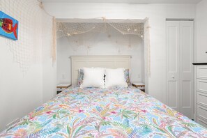 A bedroom with a bed, white headboard, and a door. - Coastal Dunedin Suite Near Beaches (Dunedin)