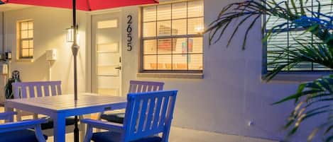A patio with a table and chairs, a red umbrella, and a house number 2655.