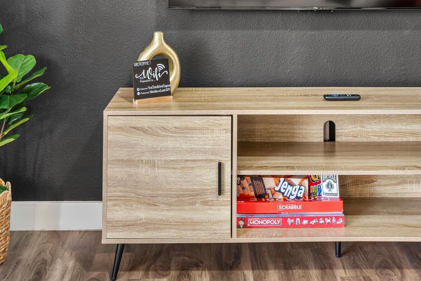 A wooden entertainment center with a TV mounted above it.