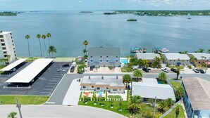 A coastal hotel with a parking lot, a pool area, and a view of the sea. - Colorful Coastal Retreat Near Honeymoon Island Beaches (Dunedin)