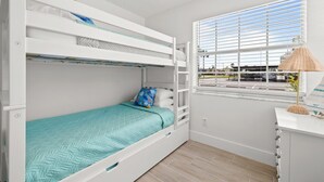 A bunk bed room with a window, a desk, and a lamp. - Colorful Coastal Retreat Near Honeymoon Island Beaches (Dunedin)