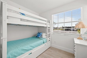 A bunk bed room with a window, a desk, and a lamp. - Colorful Coastal Retreat Near Honeymoon Island Beaches (Dunedin)