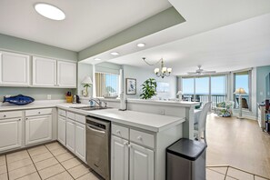 A modern kitchen with a central island, built-in cabinets, and a dishwasher. - Emerald Cove 4A - Oceanfront 4Br Condo (North Myrtle Beach)
