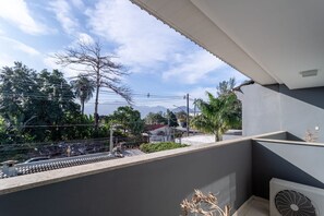 A balcony with a view of a residential area, power lines, and a clear sky. - House with Pool in a Gated Community in Recreio (Rio de Janeiro)