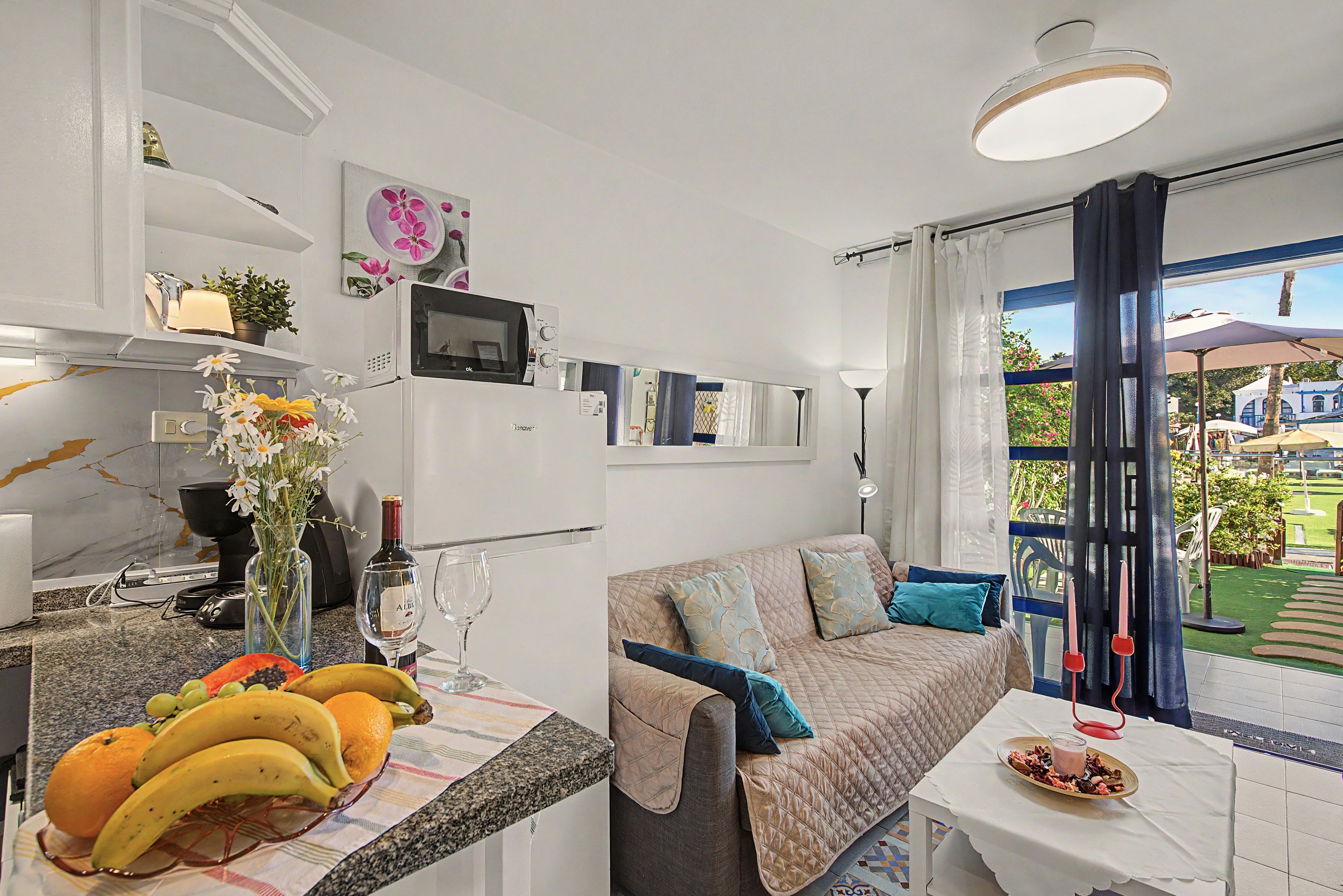 Een compacte woonruimte met een kitchenette, een eethoek en een zithoek met uitzicht.