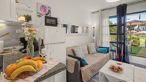A compact living space with a kitchenette, a dining area, and a seating area with a view. -  'Casa Romantico - Playmar' with Shared Pool, Private Terrace and Wi-Fi (Maspalomas)
