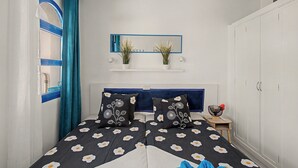 A bedroom with a bed, a mirror, a wardrobe, and a small table with a plant. -  'Casa Romantico - Playmar' with Shared Pool, Private Terrace and Wi-Fi (Maspalomas)